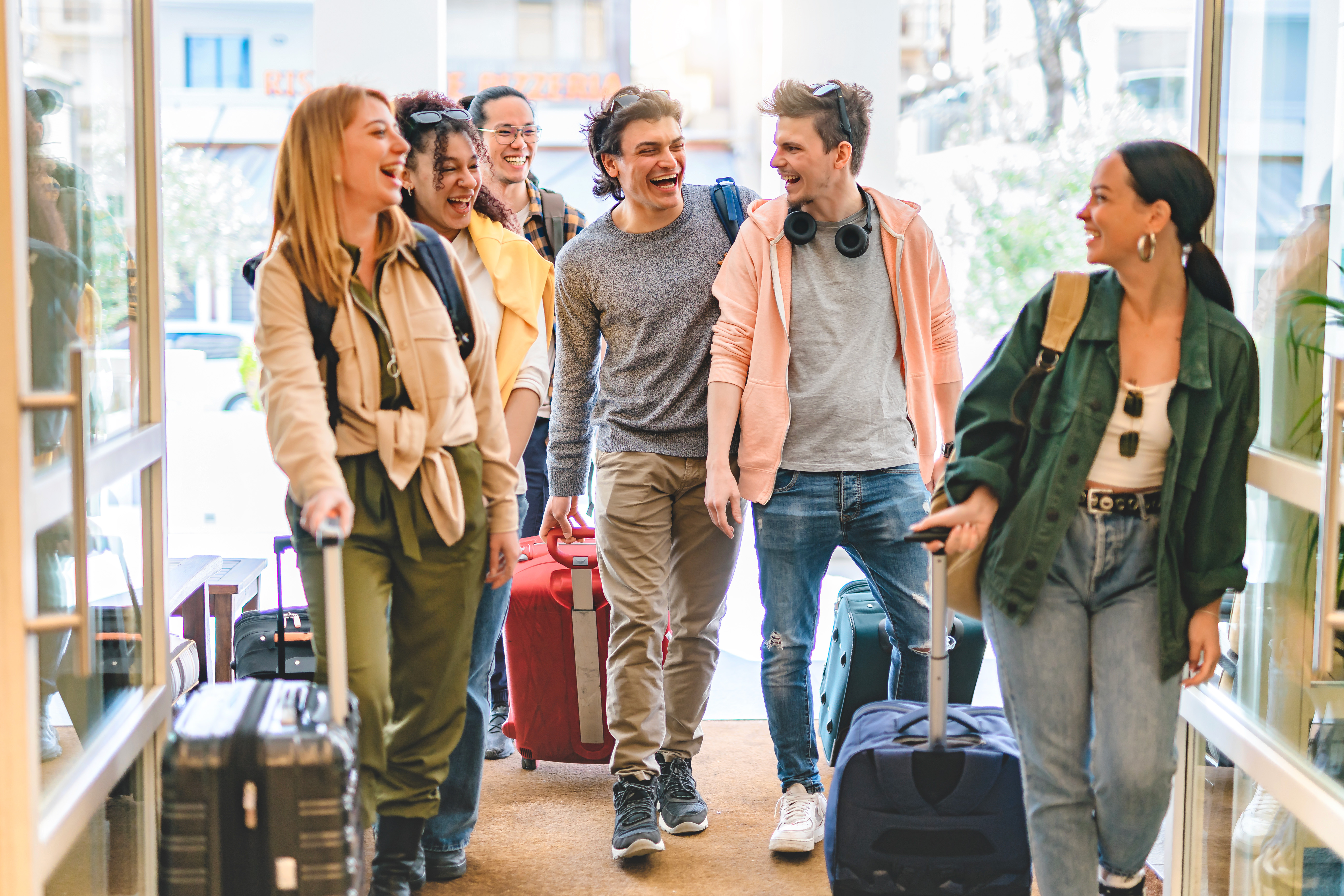 Group of young friends planning a trip together on their phones